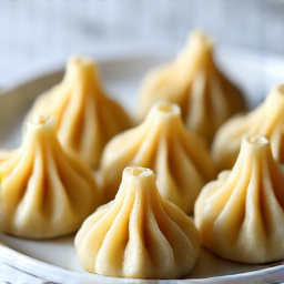 Handmade Khinkali: Georgian soup dumplings, intricately pleated, ready to be enjoyed as a traditional Caucasian delicacy.
