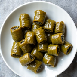 Authentic Armenian Beef Dolma. Fresh grape leaves stuffed with a savory mixture of beef, rice, and Caucasian herbs, highlighting the fusion of Mediterranean and Armenian flavors.