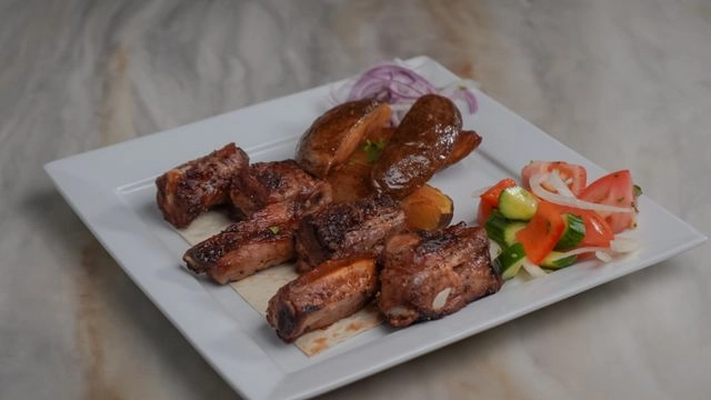 A beautifully plated dish featuring two succulent grilled lule kebabs served with a side of fluffy white rice, a fresh tomato and cucumber salad, and thinl — Yerevan Bar and Restaurant, Carmichael CA